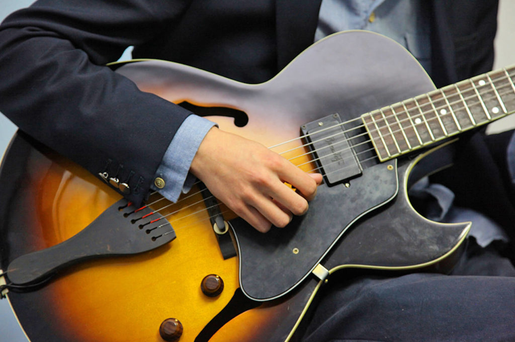 Gros plan mains sur une guitare Sciences techniques théâtre musique danse S2TMD bac lycée enseignement supérieur Fénelon groupe scolaire Estran Brest