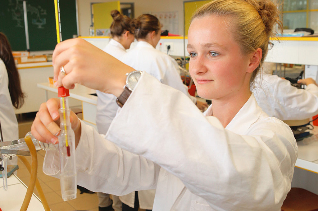 Lycéenne jeune fille adolescente manipulation en laboratoire chimie pipettes blouse blanche Sciences techniques laboratoire section STL éducation enseignement scolarité Charles de Foucauld lycée supérieur groupe scolaire Estran Brest