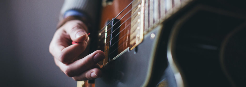Gros plan zoom sur une main qui joue de la guitare cordes instrument Sciences techniques théâtre musique danse S2TMD bac lycée enseignement supérieur Fénelon groupe scolaire Estran Brest