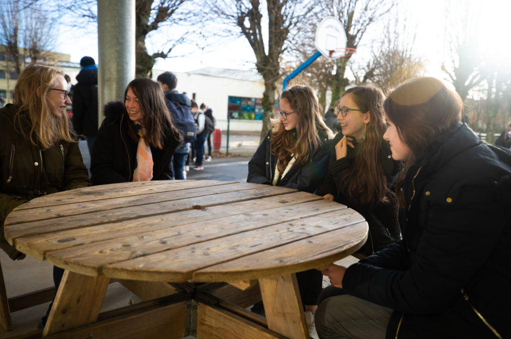 Élèves souriants autour d'une table dans la cour récréation pause école collège lycée Charles de Foucauld Brest enseignement éducation © MarcGlenPhotographie