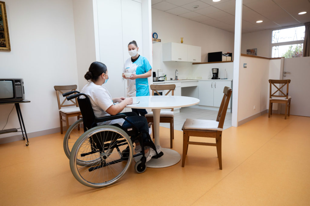 Femme fauteuil roulant à table soins à domicile BAC PRO ASSP Estran ©MarcGlenPhotographie
